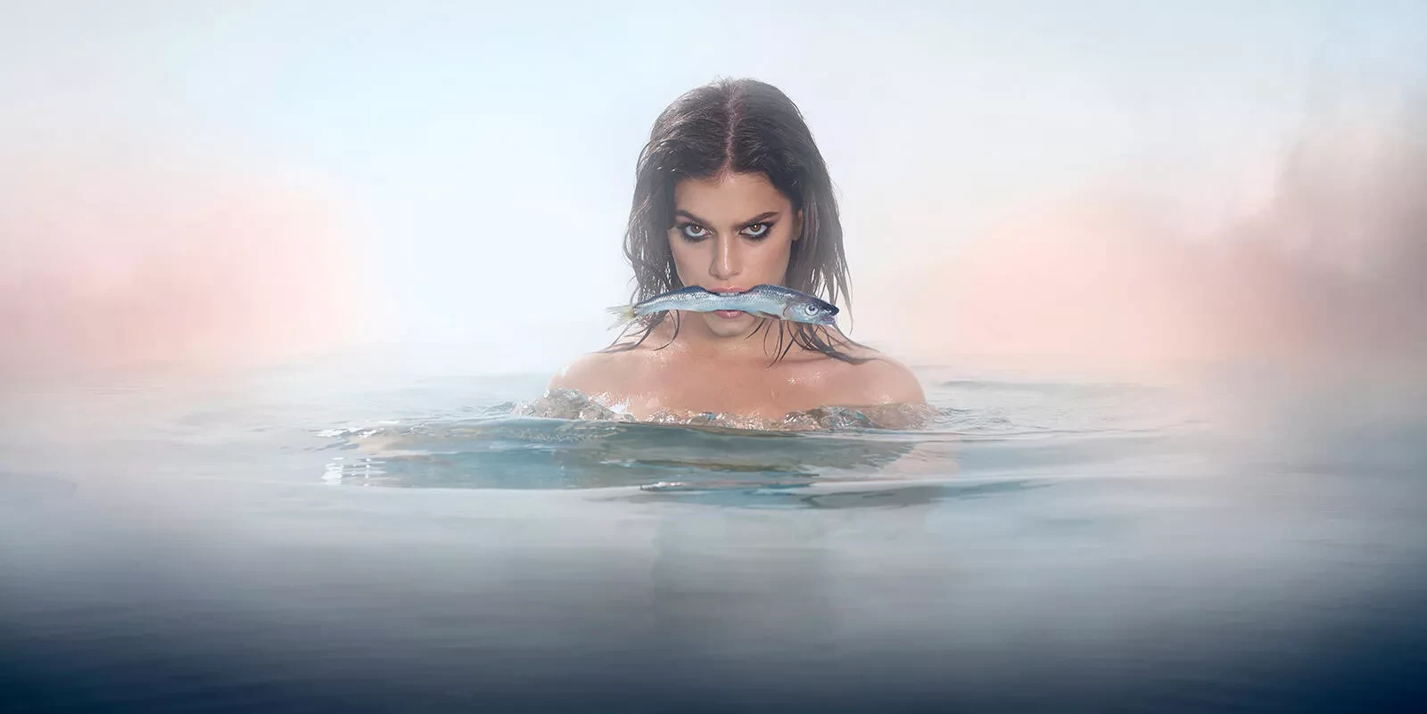 Vrouw in het water met vis in de mond